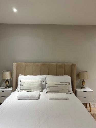 a bedroom with a large white bed with two lamps at Spacious 2BR Apartment with Terrance in London