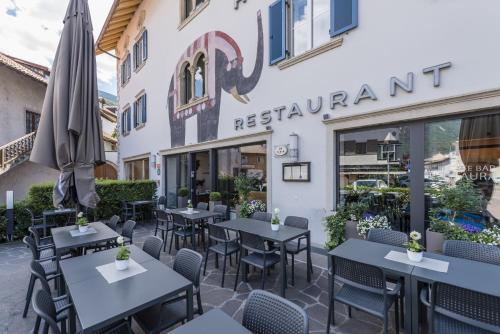 a restaurant with tables and chairs in front of a building at Hotel Elefant in Auer