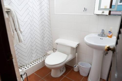 a white bathroom with a toilet and a sink at Gorgeous Apt w/ Best Views of La Fortaleza in San Juan
