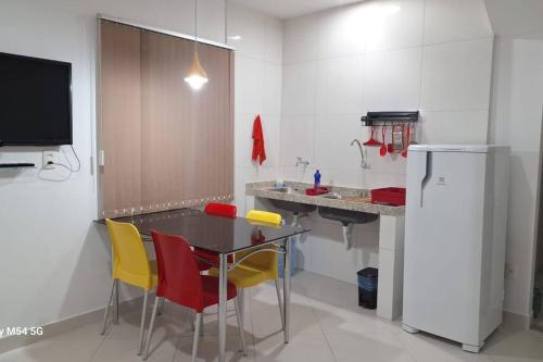 Apartamento top central في Pau dos Ferros: مطبخ مع طاولة وكراسي وثلاجة