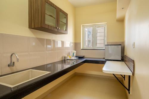 a kitchen with a sink and a counter top at MK Residency in Coimbatore