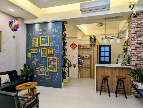 een woonkamer met een muur met een schoolbord bij Ramble Travel Homestay in Guanshan