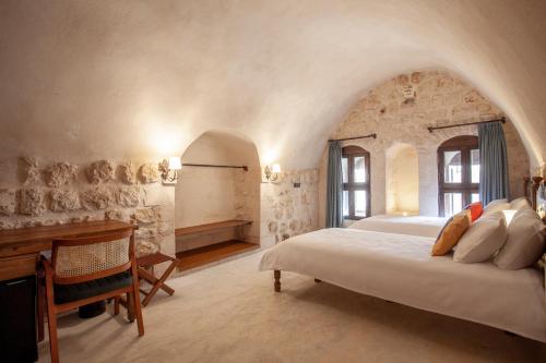 a bedroom with a bed and a desk in a room at Hakkı Bey Konağı in Savur