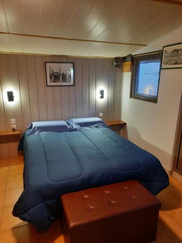 Un dormitorio con una gran cama azul y una mesa en La Palmeraie, en Istres