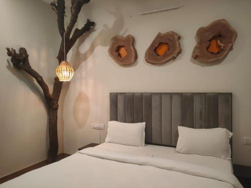 a bedroom with a tree and a bed with donuts on the wall at Villa Wonderland in Udaipur