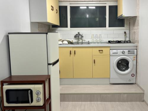 a kitchen with a refrigerator and a washing machine at Our secret movie theater, Netflix, popcorn, free parking in Seoul