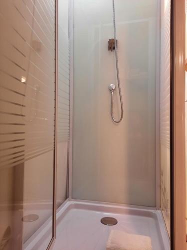 cabina de ducha con puerta de cristal y ducha en La Palmeraie, en Istres