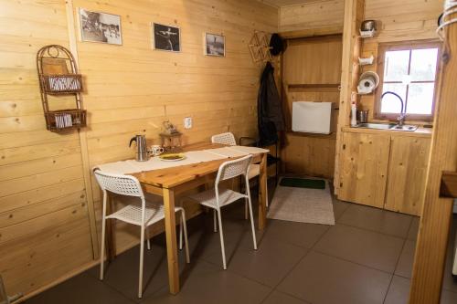 - une salle à manger avec une table et des chaises en bois dans l'établissement Drewniany domek pod masywem Śnieżnika, à Nowa Morawa