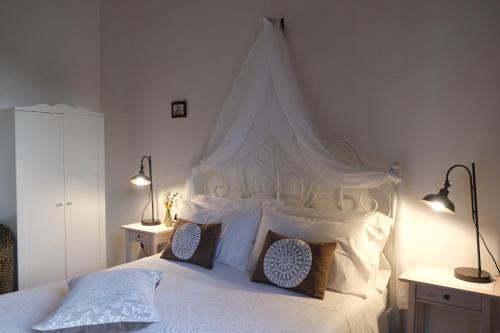 a bedroom with a large white bed with two lamps at Dimora Amina in Loreto Aprutino
