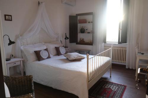 a bedroom with a white bed with a white canopy at Dimora Amina in Loreto Aprutino