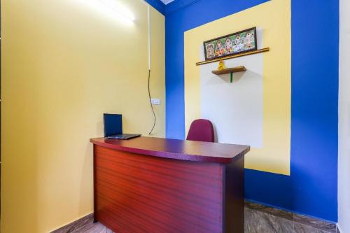 a desk in a room with a blue wall at Simsan Inn in Chennai