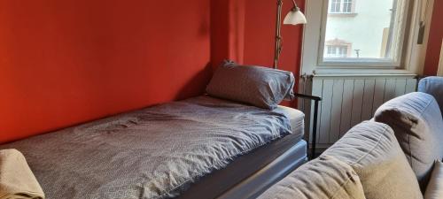a bed in a room with an orange wall at Eden Apartment Budapest in Budapest