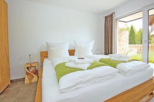 two white beds in a room with a window at Rusticoy in Oy-Mittelberg