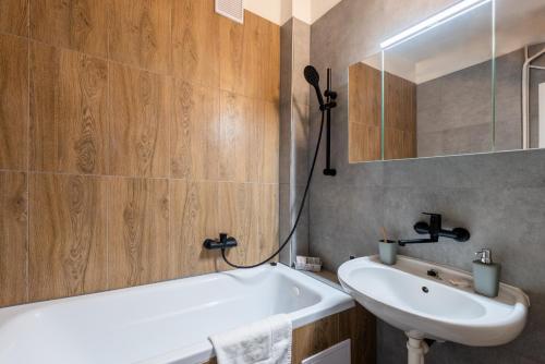 a bathroom with a white tub and a sink at Prague - Karlin Apartments in Prague