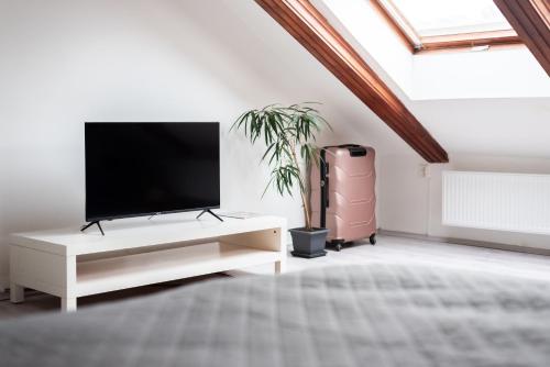 a white living room with a tv on a white cabinet at Prague - Karlin Apartments in Prague