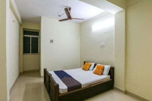 a bedroom with a bed with a ceiling fan at Simsan Inn in Chennai