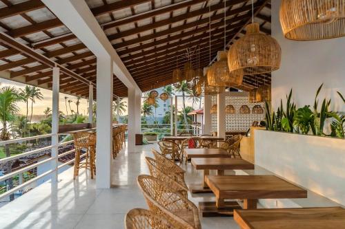 a restaurant with wooden tables and chairs at Lucky's Surf Camp in Weligama