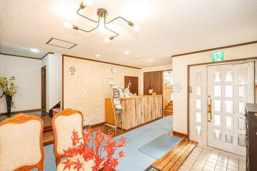 a living room with a table and chairs and a door at 団体歓迎ジョイサウンドカラオケ付き北軽井沢超大型貸別荘7寝室5浴室20人泊まれる in Karuizawa