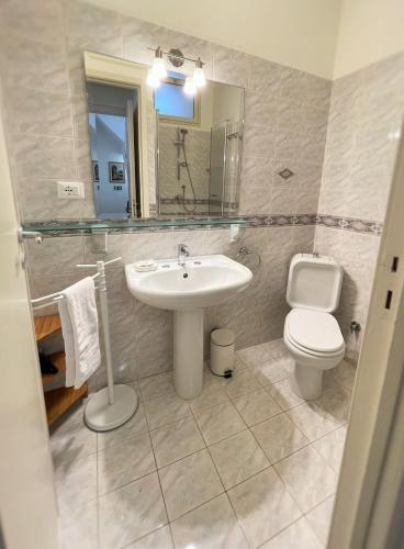 a bathroom with a sink and a toilet and a mirror at B&B Evelyne in Taormina