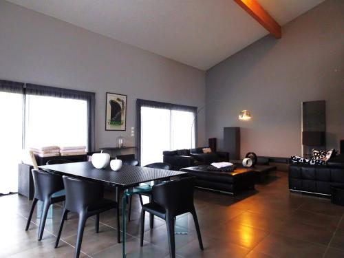 un salon avec une table et des chaises noires dans l'établissement Magnifique villa 220m2- Quartier résidentiel Le Carreyrat - 6 à 8 pers - 3 chambres doubles - Grand jardin et terrasses, à Montauban