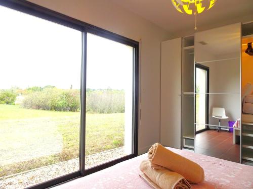 1 dormitorio con ventana grande con vistas a un campo en Magnifique villa 220m2- Quartier résidentiel Le Carreyrat - 6 à 8 pers - 3 chambres doubles - Grand jardin et terrasses, en Montauban