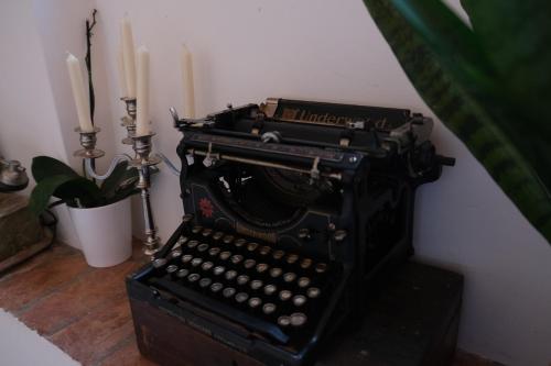 an old fashioned typewriter with two candles and a plant at Dimora Amina in Loreto Aprutino