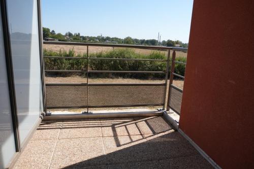 a door to a balcony with a view of a field at Zenao Appart'Hotel in Yzeure