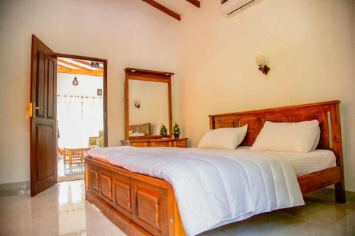 una camera da letto con un grande letto con lenzuola bianche di Healand Holiday Bungalow and Restaurant a Deniyaya
