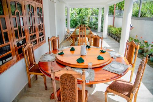 uma sala de jantar com uma mesa de madeira e cadeiras em Healand Holiday Bungalow and Restaurant em Deniyaya