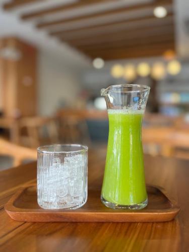 a green drink and a glass on a wooden tray at Tiya House Rooms & Cafe in Krabi town