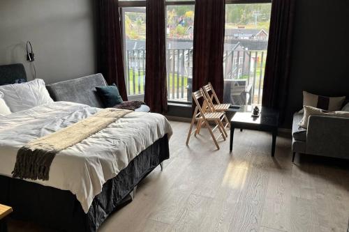 ein Schlafzimmer mit einem Bett, einem Sofa und einem Fenster in der Unterkunft Topp studio leilighet Alpine Lodge in Trysil