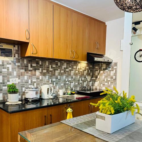a kitchen with wooden cabinets and a counter top at Emotera Place @ Arezzo Place Davao in Davao City