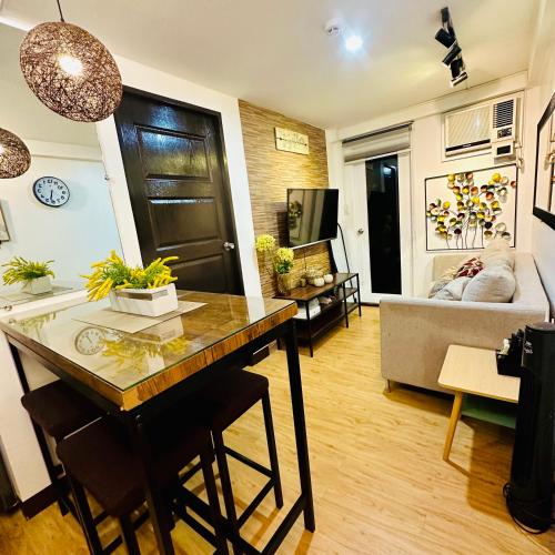 a living room with a table and a couch at Emotera Place @ Arezzo Place Davao in Davao City