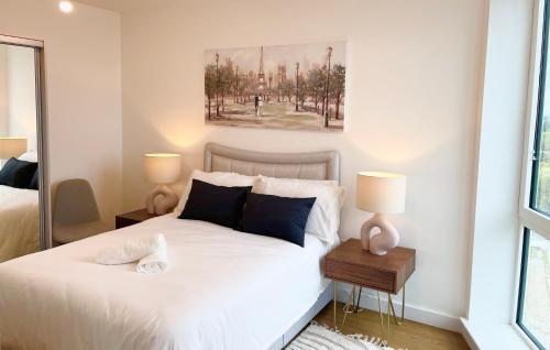 ein Schlafzimmer mit einem weißen Bett mit zwei Lampen in der Unterkunft Urban Gateway Spacious Apartment with free parking in Bracknell
