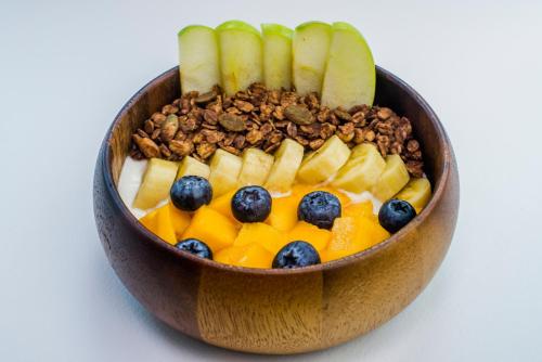 a wooden bowl filled with fruit and nuts at Tiya House Rooms & Cafe in Krabi town