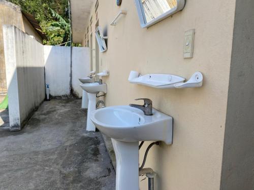 eine Reihe von Waschbecken auf der Seite eines Gebäudes in der Unterkunft Homestay-Nhà Sàn Ngán Chải in Ha Giang