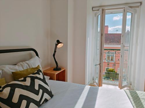 a bedroom with a bed and a window with a view at Jerónimos Apartments best place in Lisbon - 1º D in Lisbon