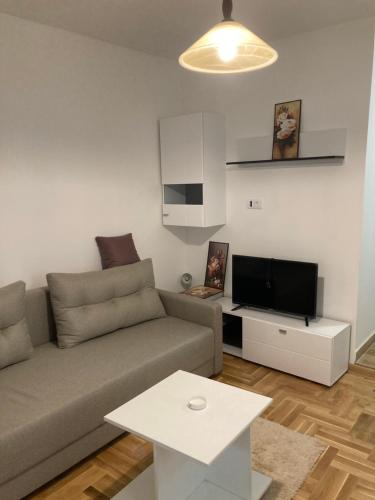 a living room with a couch and a tv at Luks MM 5 in Pančevo