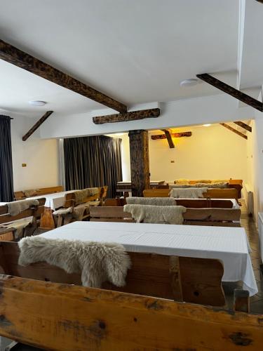 ザルネシュティにあるPensiunea Andalexのベッドルーム1室(大型ベッド1台、白いシーツ、椅子付)