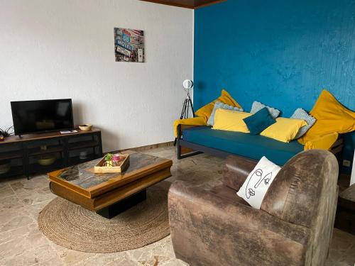 uma sala de estar com um sofá e uma mesa de centro em Pivoine em Bellegarde-sur-Valserine