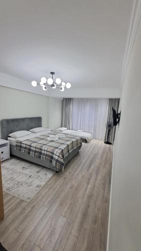 a white bedroom with a bed and a wooden floor at Аэропорт Апартаменты 24&24 in Chişinău