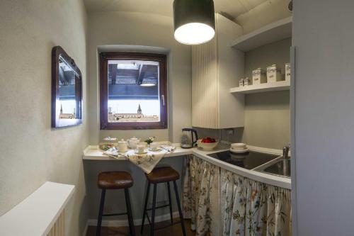 a kitchen with a bar with two stools and a sink at Residenza...Cara Giulietta... in Verona