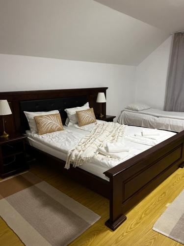 ザルネシュティにあるPensiunea Andalexのベッドルーム(白いシーツを使用した大型ベッド1台付)