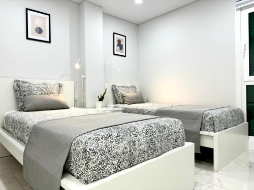 プラヤ・デ・ラス・アメリカスにあるLas Viñas Apartmentの白い壁のベッドルーム1室(ベッド2台付)