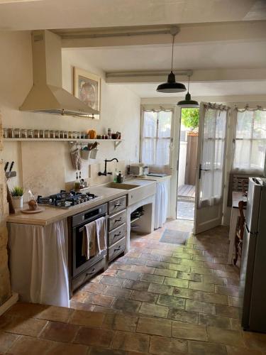 une cuisine avec un évier et une cuisinière dans l'établissement LA PETITE MAISON DE MAUSSANE ***, à Maussane-les-Alpilles