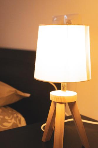 a wooden lamp with a white lamp shade on a table at Casa amb molt encant i tranquilitat. in Ansalonga