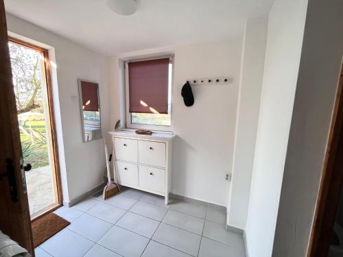 a white room with a window and a dresser at Vila blizu Beograda - My Family Cottage in Ba°evac