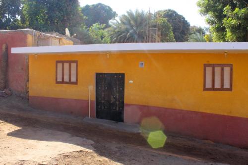 a small yellow and red building with a door at Hamo Guest House in Aswan