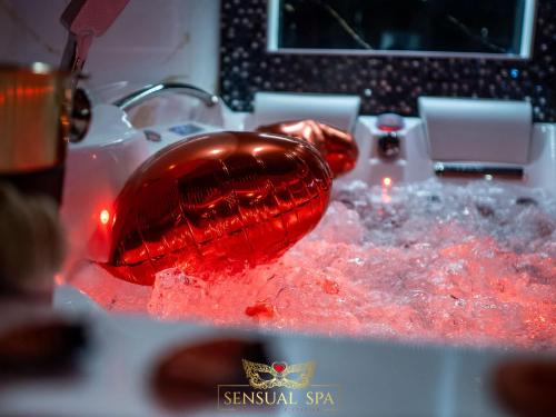un bol en verre rouge assis au-dessus d'un évier dans l'établissement Sensual SPA- Love ROOM Jacuzzi Hammam Terrasse, à Nancy