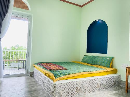 Bett mit blauem Kopfteil in einem Zimmer in der Unterkunft Gió Homestay and Coffee in Ấp Khánh Phước (1)